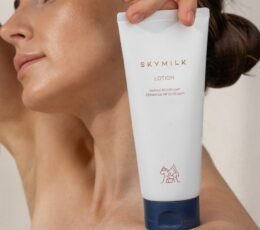 Modelis laiko SKYMILK Lotion kuno losjono pakuote prie veido
